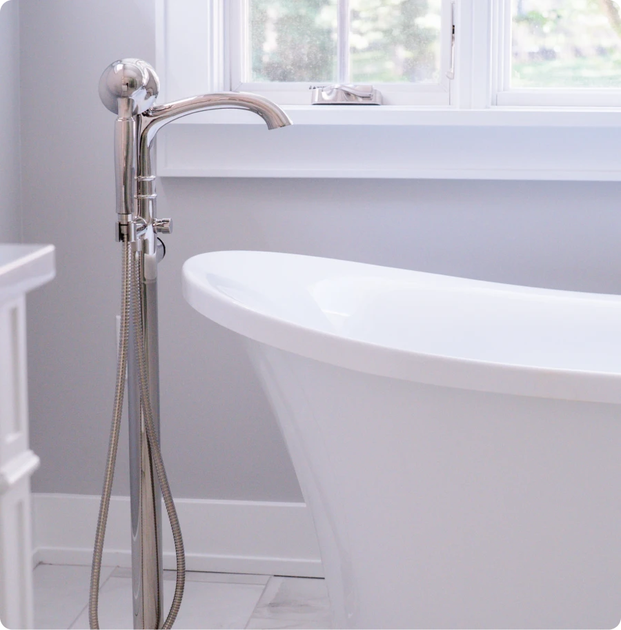 A white bathtub positioned beside a window, allowing natural light to illuminate the space.